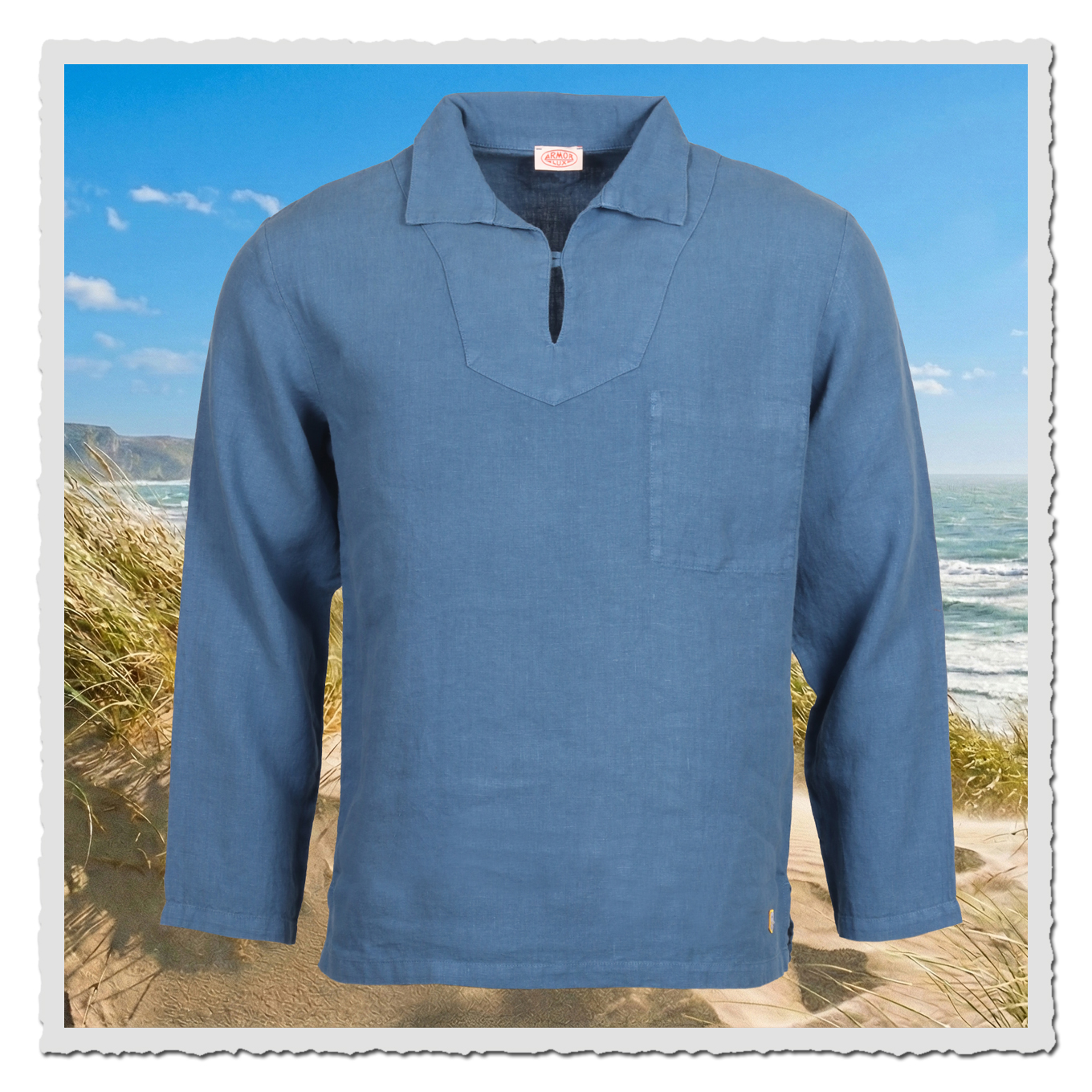 Leichtes blaues Herren-Fischerhemd von Armor Lux aus Leinen, locker geschnitten mit Ausschnitt und Brusttasche, Strandszene im Hintergrund.